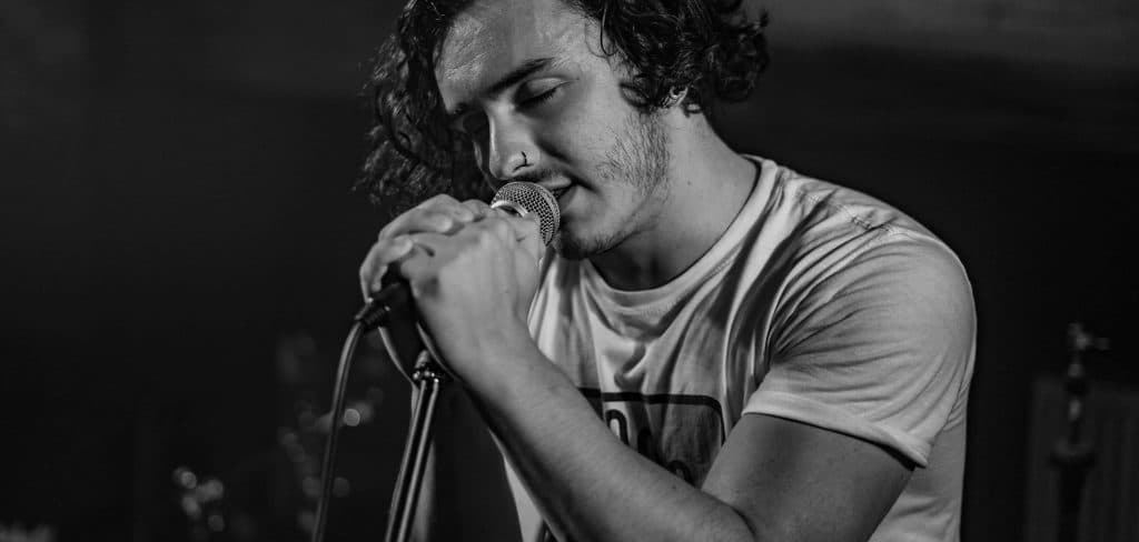 Elliot Stradling sings into his microphone at a live gig